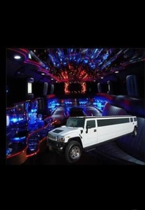 A white hummer limo is parked in the middle of a room.